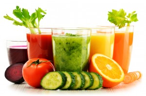 Glasses with fresh organic vegetable and fruit juices on white